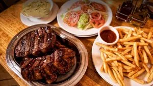 corte de carne de res asada, papas fritas, puré, y ensalada un servicio del restaurante donde joselito